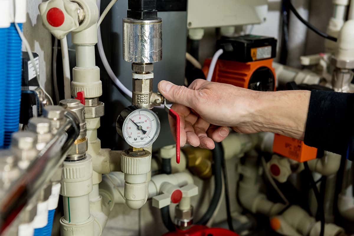 Heating engineer fixing modern heating system in boiler room