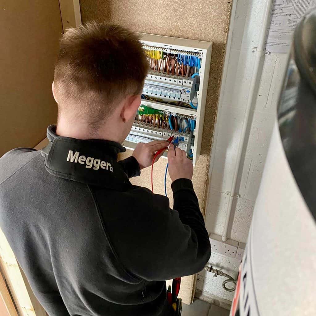 Deakins-Electrician-wiring-a-circuitboard